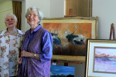 Vlnr is Hettie Oosthuizen en Olga Swanepoel by Olga se skildery, â€œParingsdansâ€ in die agtergrond